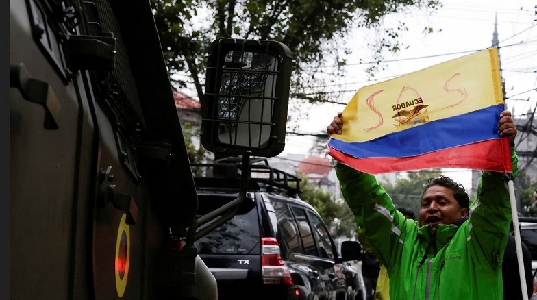 Un manifestante, junto al convoy de seguridad que trasladaba a Jorge Glas a prisión, el 6 de abril de 2024. KAREN TORO (REUTERS)