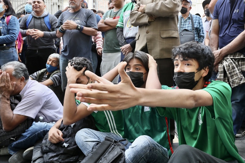Aficionados al futbol ven el partido de la Selección Mexicana contra Arabia Saudita, durante la Copa Mundial de Qatar, al exterior de un negocio en la avenida Madero, en el Centro Histórico capitalino, el 30 de noviembre de 2022. Foto Roberto García Ortiz