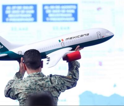 Un soldado del ejército acomoda una maqueta de un avión de Mexicana durante la conferencia de prensa, en el Palacio Nacional, en Ciudad de México (México). SÁSHENKA GUTIÉRREZ (EFE)