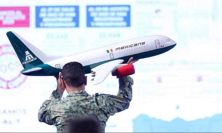 Un soldado del ejército acomoda una maqueta de un avión de Mexicana durante la conferencia de prensa, en el Palacio Nacional, en Ciudad de México (México). SÁSHENKA GUTIÉRREZ (EFE)