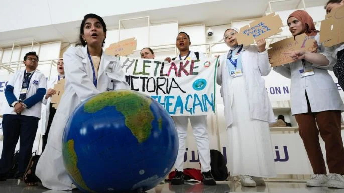 Una mujer simula reanimar a la Tierra en una manifestación en la conferencia climática COP28. Foto: AP Foto/Peter Dejong