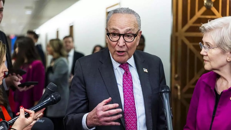 El líder de la minoría del Senado de Estados Unidos, Chuck Schumer (C), junto a la senadora demócrata por Massachusetts, Elizabeth Warren (R). EFE/JIM LO SCALZO