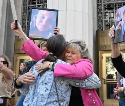 Lori Schott, centro, sostiene una foto de su hija Annalee Schott, tras el veredicto en un trascendental juicio sobre si las redes sociales vuelven adictos y perjudican deliberadamente a los menores en el Tribunal Superior de Los Ángeles, el miércoles 25 de marzo de 2026, en Los Ángeles. (William Liang / Associated Press)