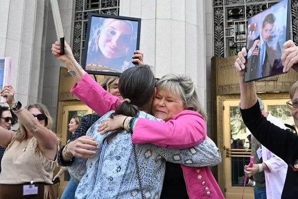 Lori Schott, centro, sostiene una foto de su hija Annalee Schott, tras el veredicto en un trascendental juicio sobre si las redes sociales vuelven adictos y perjudican deliberadamente a los menores en el Tribunal Superior de Los Ángeles, el miércoles 25 de marzo de 2026, en Los Ángeles. (William Liang / Associated Press)