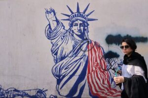 Una mujer pasa ante un mural en la pared de la antigua embajada de Estados Unidos en Teherán, ahora convertida en un museo. Foto: AP 