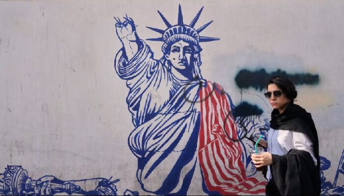 Una mujer pasa ante un mural en la pared de la antigua embajada de Estados Unidos en Teherán, ahora convertida en un museo. Foto: AP 