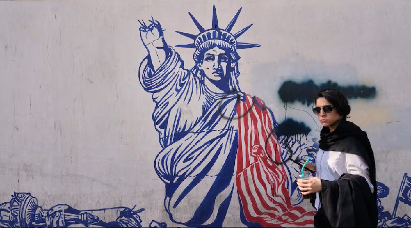 Una mujer pasa ante un mural en la pared de la antigua embajada de Estados Unidos en Teherán, ahora convertida en un museo. Foto: AP